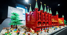 eine Burg aus Legosteinen mit Bäumen und Menschen