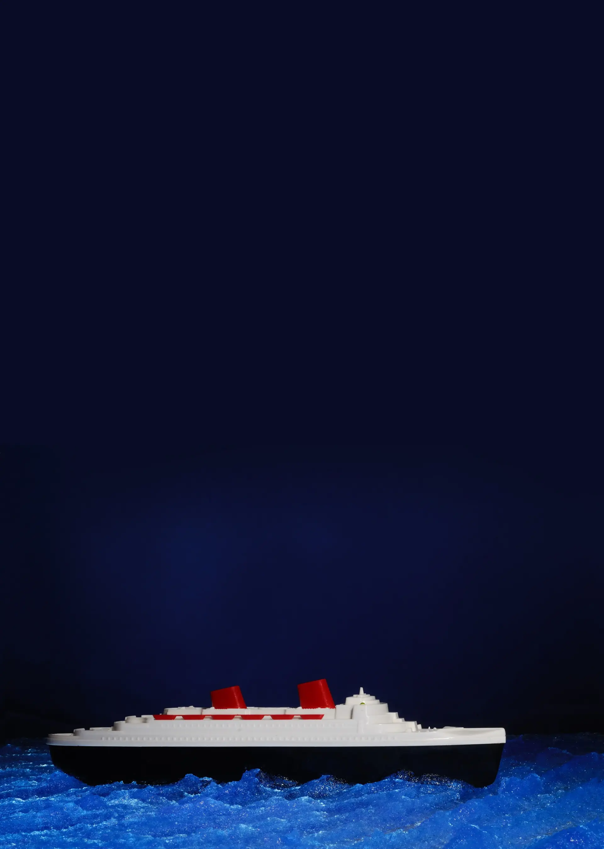 Im Bild fährt ein Spielzeugschiff aus Plastik in der Nacht