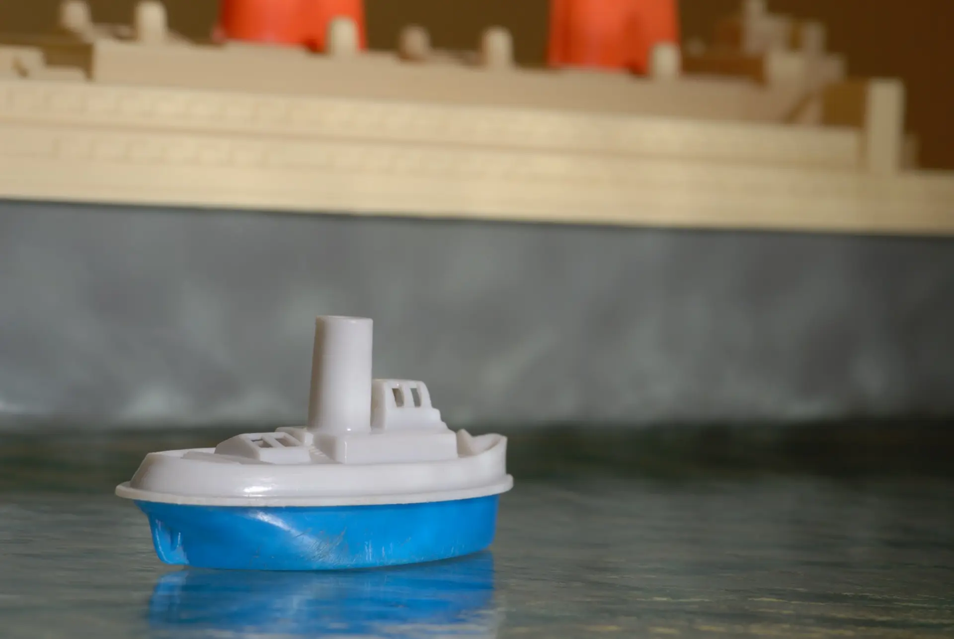 Ein Plastikspielzeugboot steht vor einer Mauer